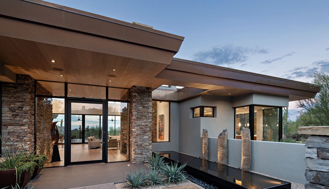 Desert Highlands Contemporary entry courtyard with stacked-stone columns, glass walls and modern water feature