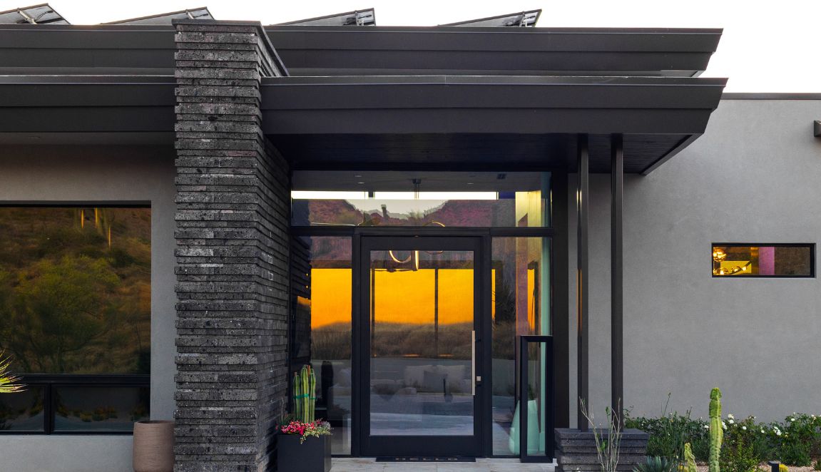 Legend Canyon Contemporary front entry with dark stacked-stone column, glass door and clean modern rooflines