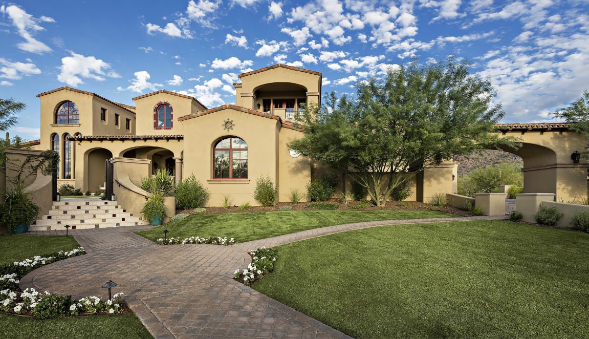 Silverleaf Spanish Colonial front exterior with arched windows, tiled roof, landscaped lawn and covered porte-cochere